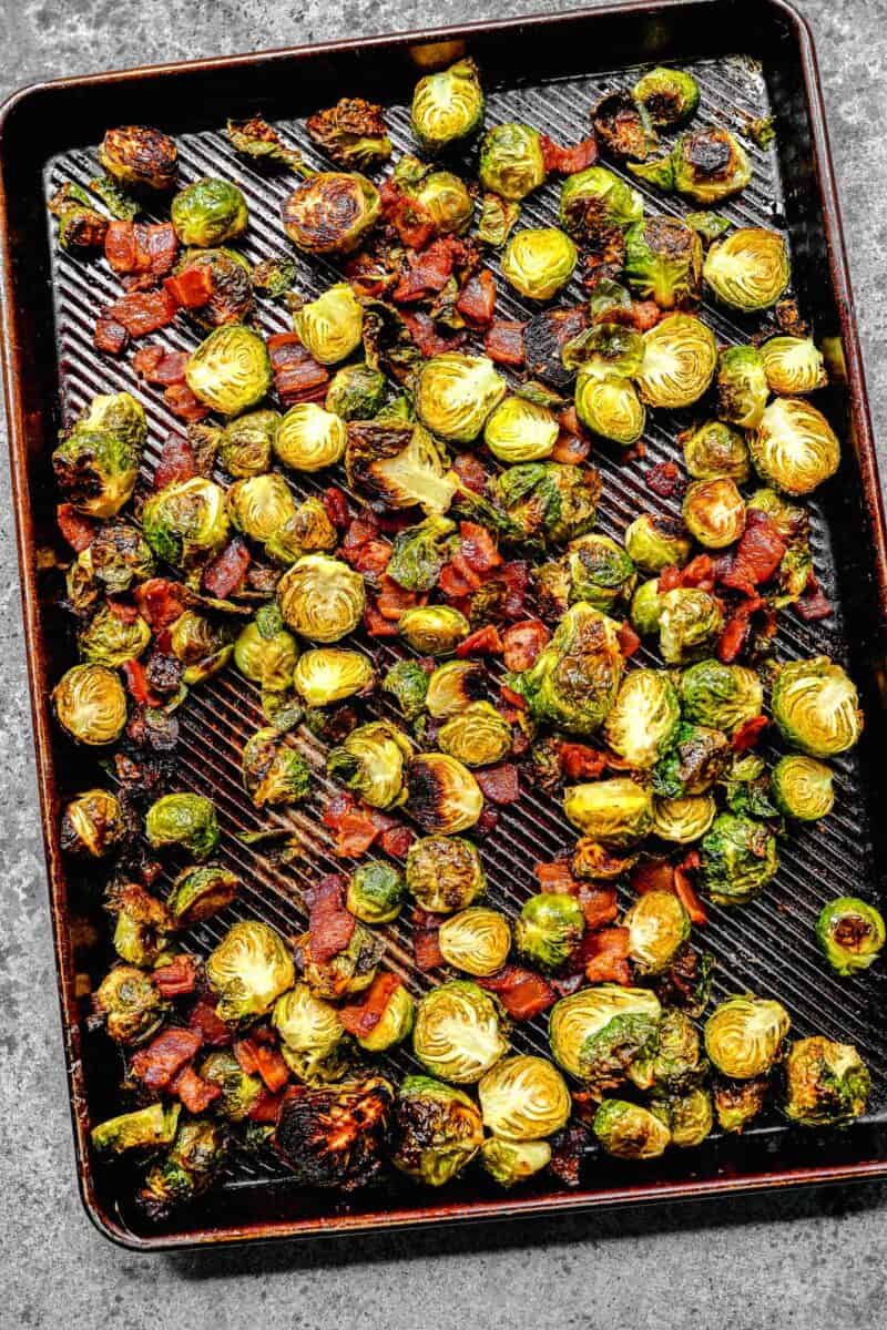 roasted brussels sprouts and bacon on a rimmed baking sheet