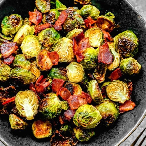 bacon and brussels sprouts in a black ceramic bowl