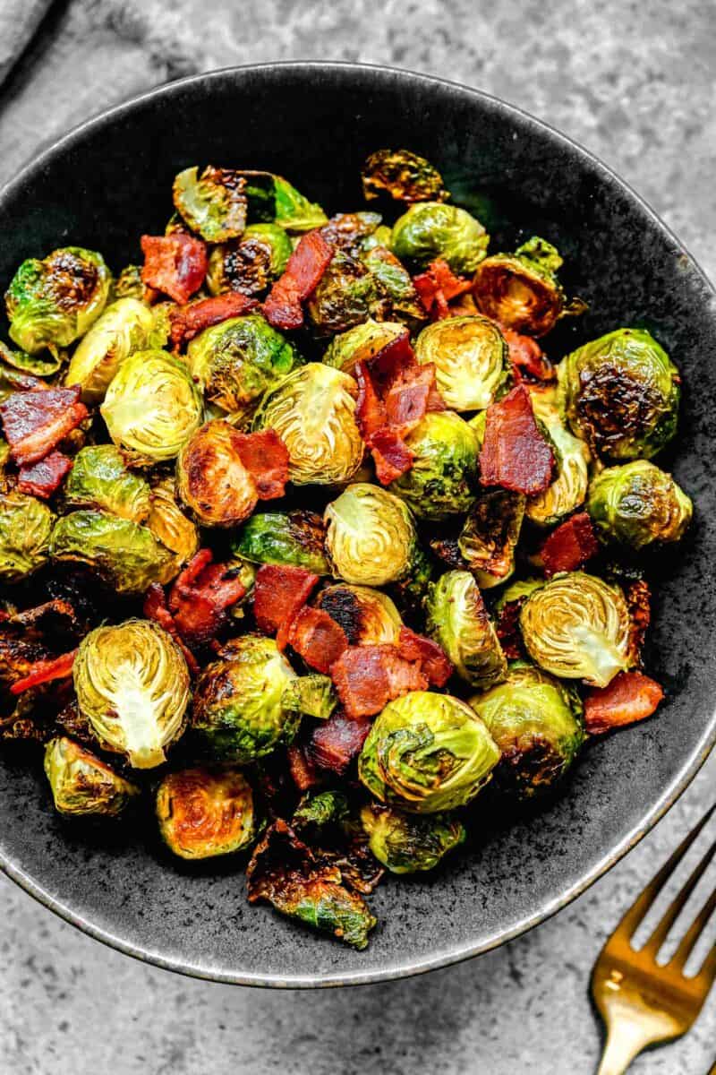 bacon and brussels sprouts in a black ceramic bowl