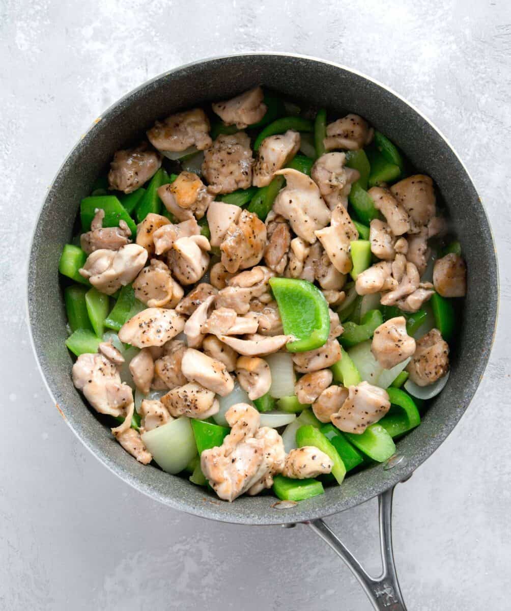 cooked chicken thigh pieces with the green bell pepper, onion, and celery mixture