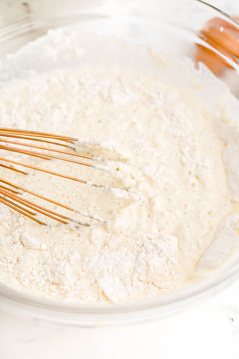 dry pancake mix is being whisked with a spoon.