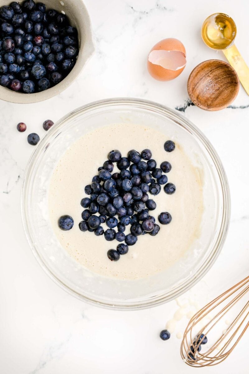 blueberries are being mixed into pancake batter.