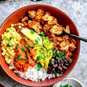 a burrito bowl is served with plenty of vibrant toppings.
