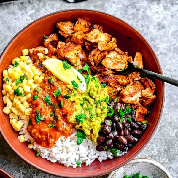 a burrito bowl is served with plenty of vibrant toppings.