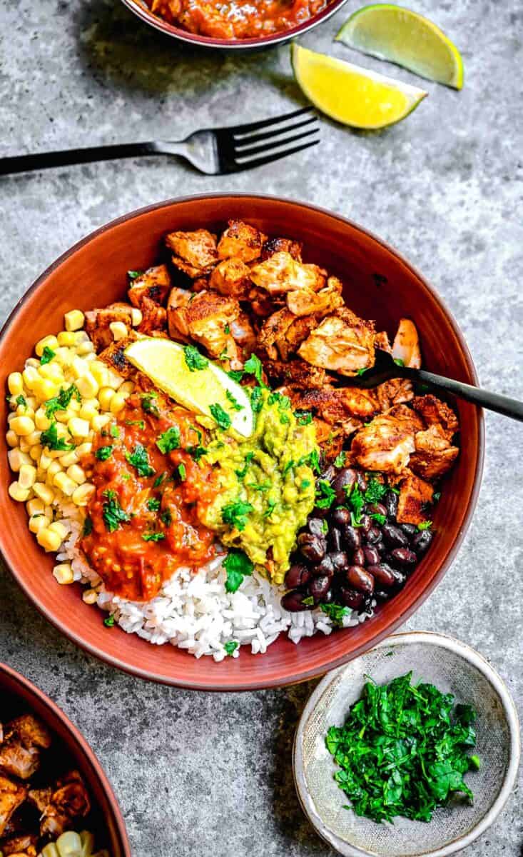 a burrito bowl is served with plenty of vibrant toppings.