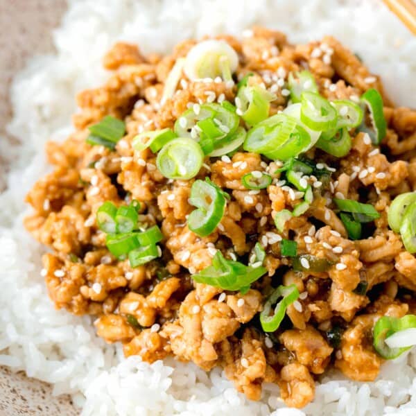 ground chicken teriyaki in a speckled brown bowl on top of white rice