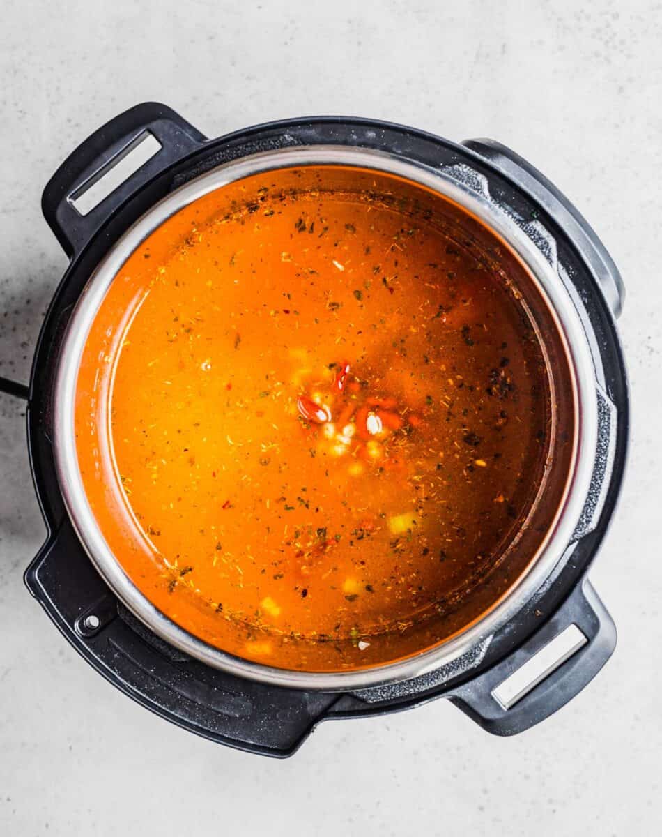 a red broth fills the instant pot.