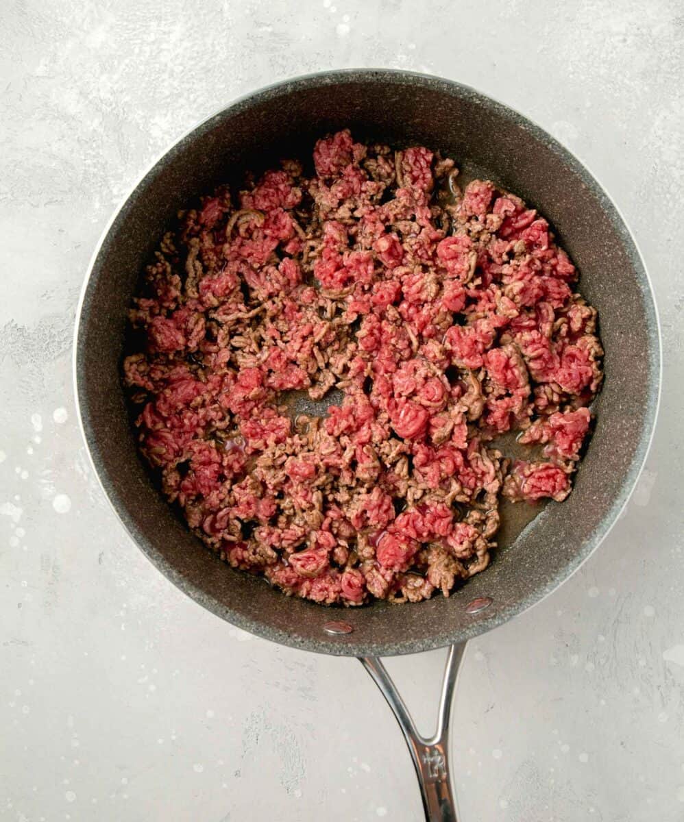 browning and breaking apart ground beef in a skillet