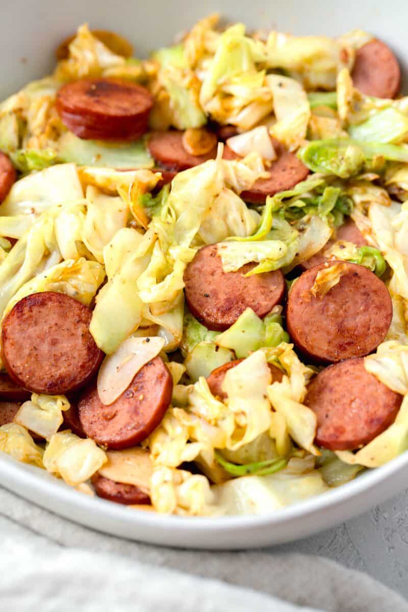 sauteed cabbage and sausage in a white bowl