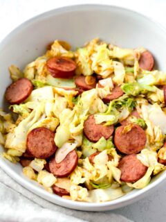 sauteed cabbage and sausage in a white bowl