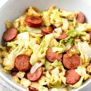 sauteed cabbage and sausage in a white bowl