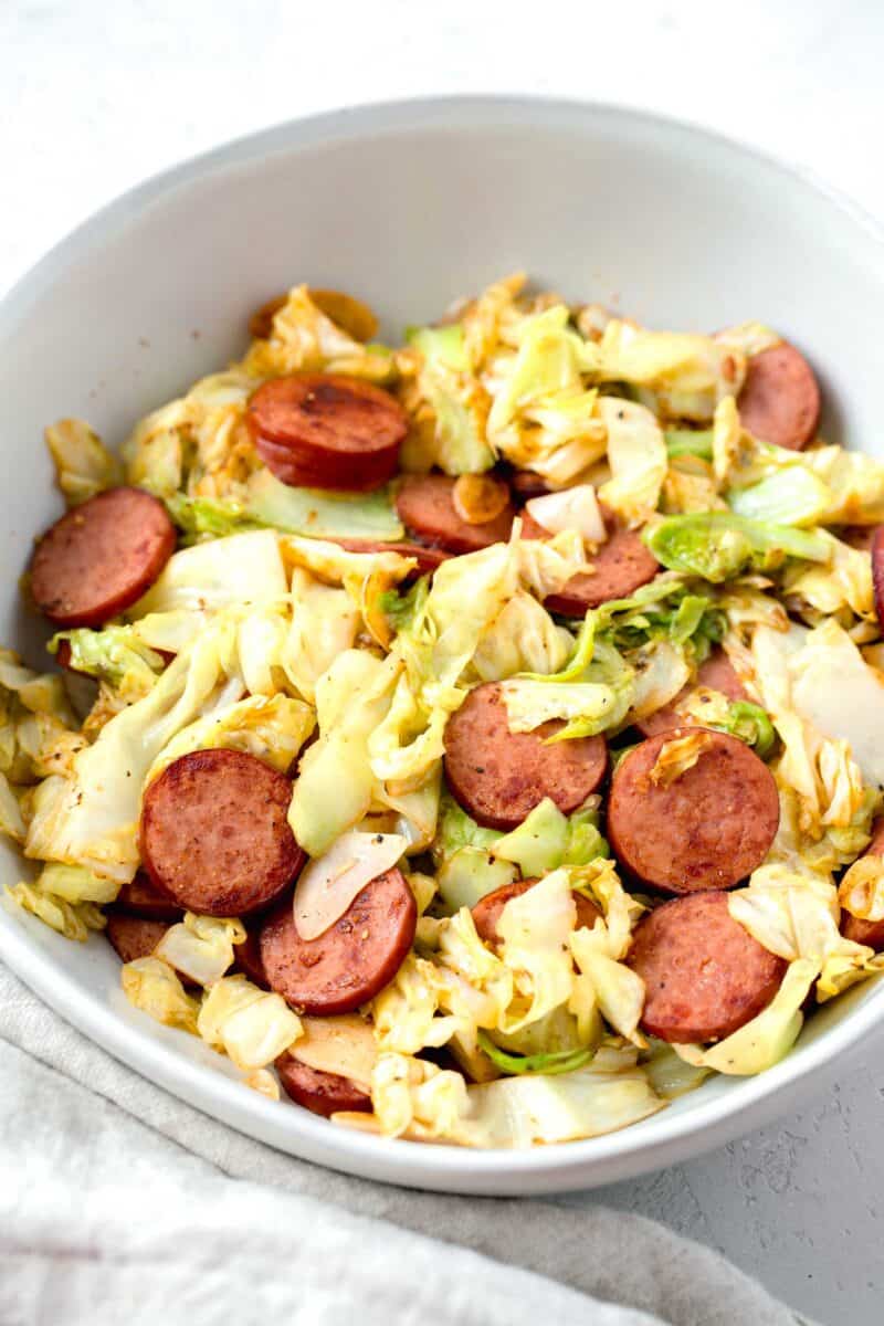 sauteed cabbage and sausage in a white bowl