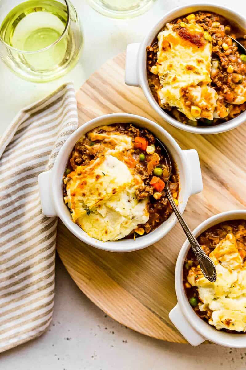 a spoon is placed in a bowl filled with shepherd's pie.