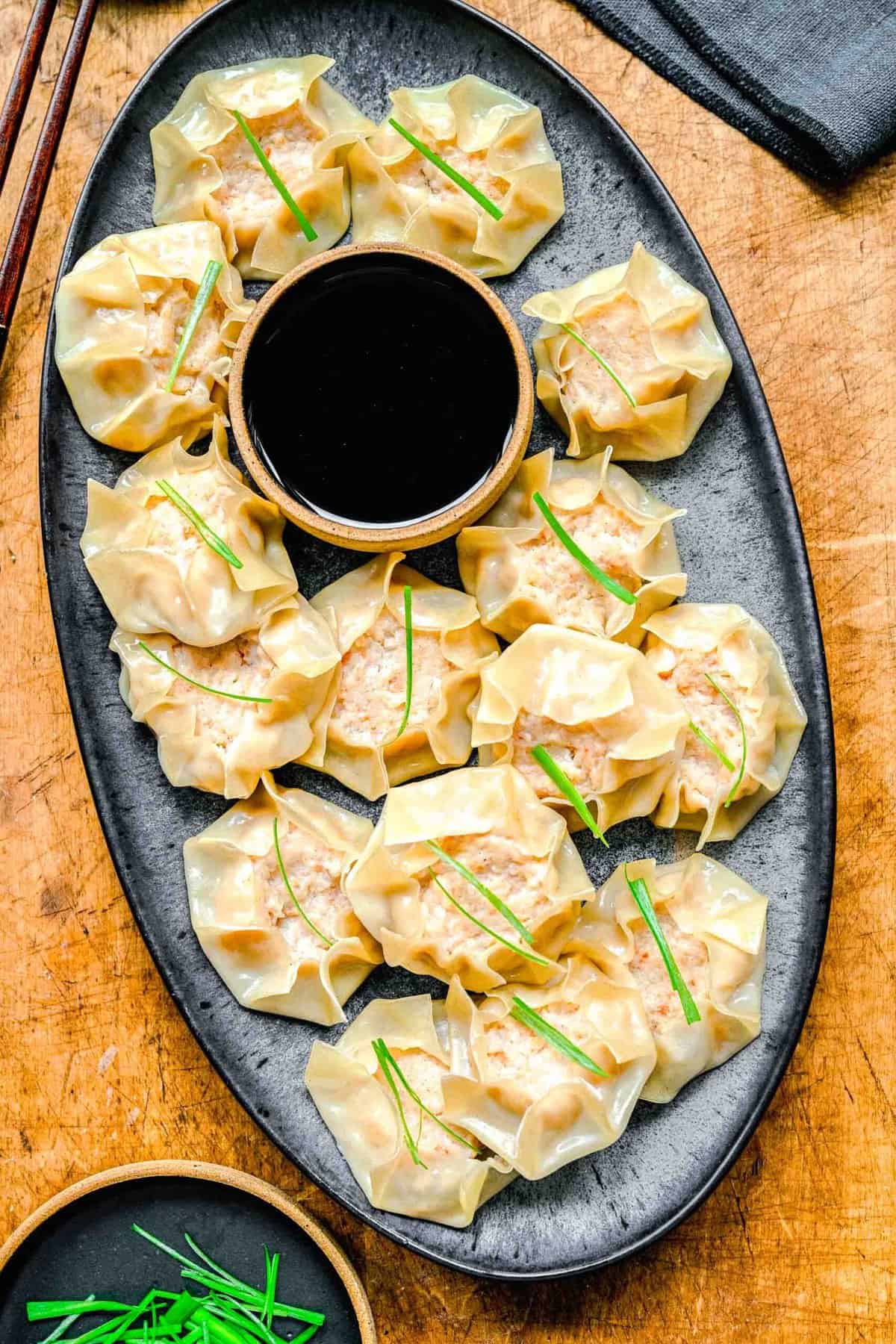 Shrimp shumai on a plate with soy sauce.