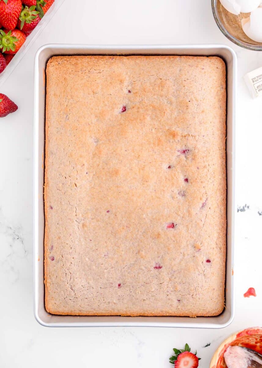 baked strawberry sheet cake in a metal rimmed baking pan