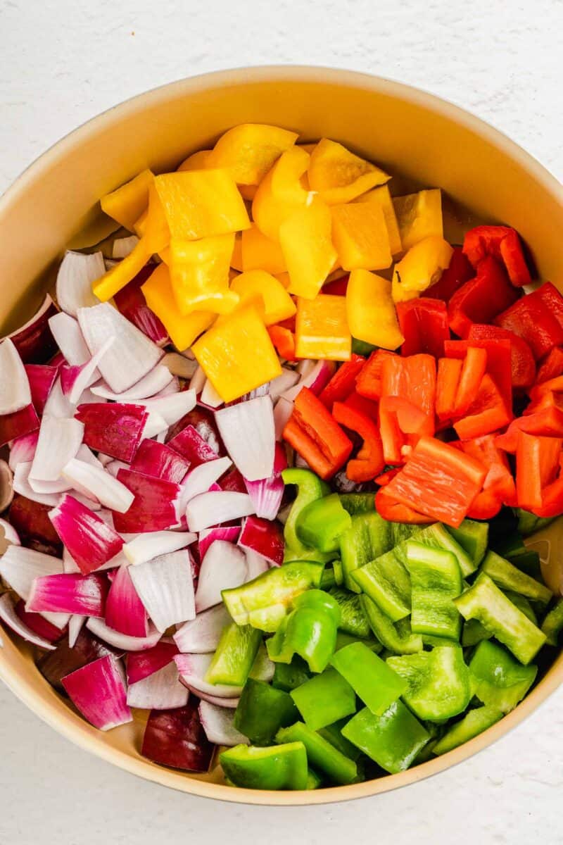 Uncooked veggies are placed next to one another in a large pot.