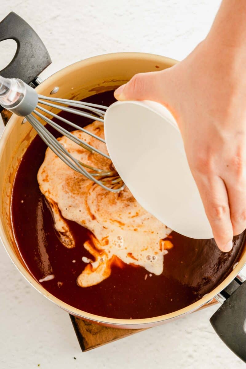 A cornstarch slurry is being poured into the sauce ingredients.