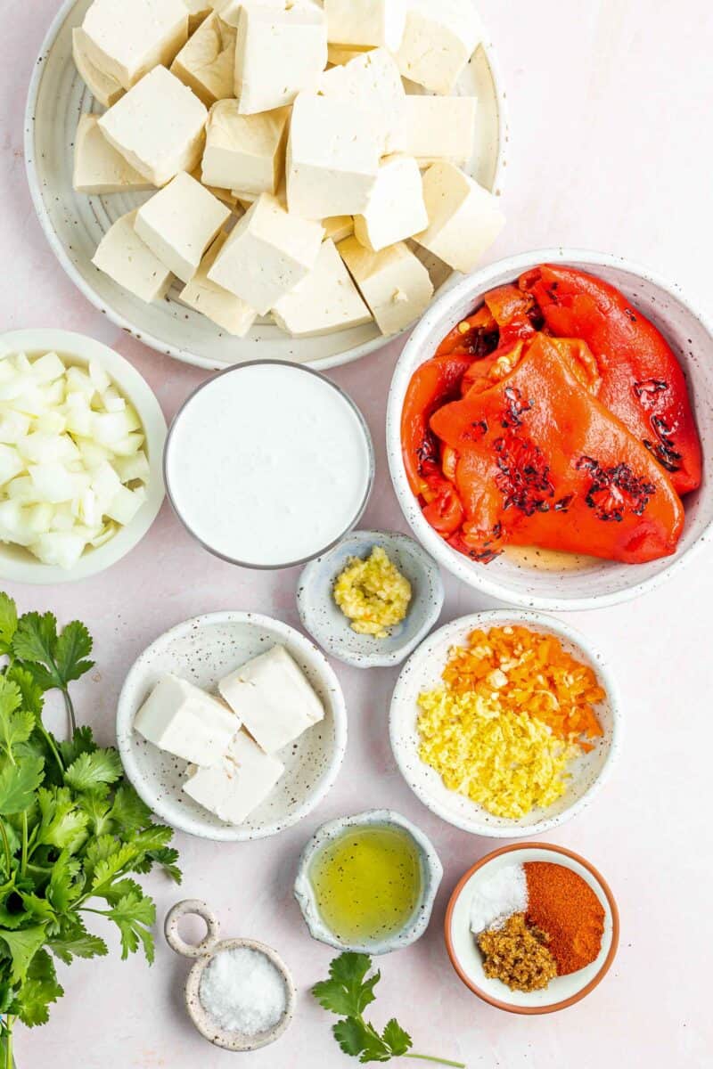 ingredients for tofu coconut curry: tofu, roasted red bell peppers, habanero pepper, ginger, spices, oil, salt, butter, garlic, coconut milk, and onions