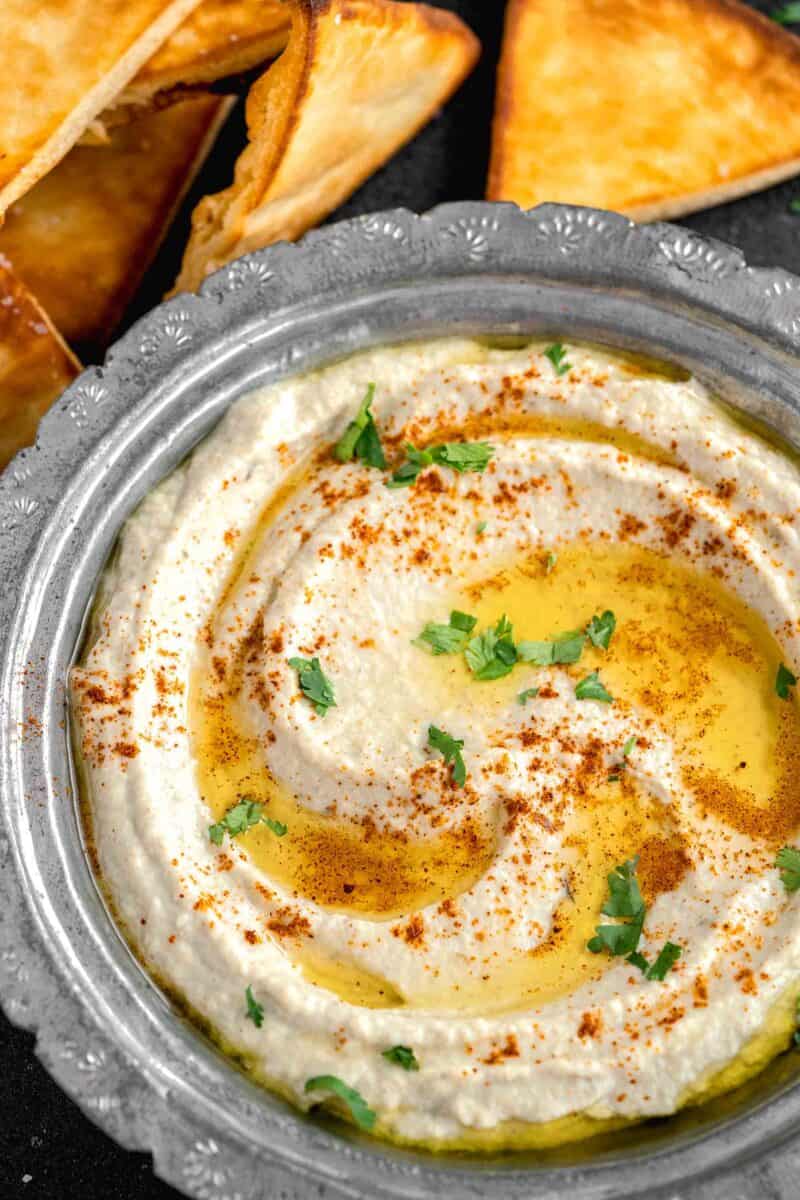 pita chips are placed next to a bowl of Baba Ganoush.