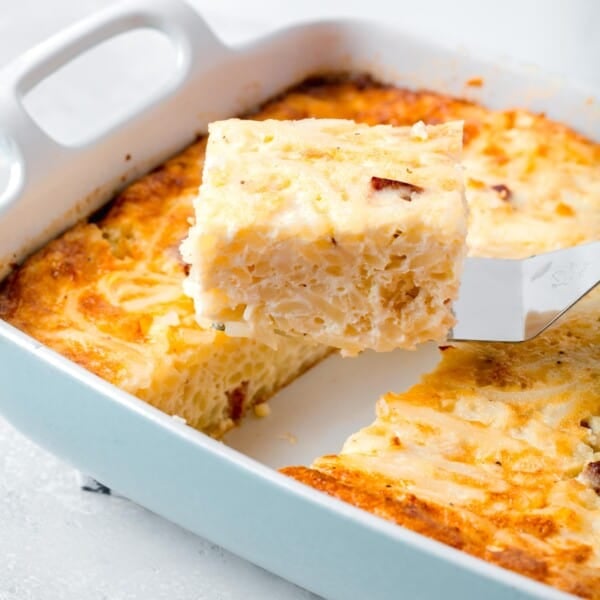 a slice of egg white breakfast casserole on a metal spatula being lifted up from the rest of the casserole