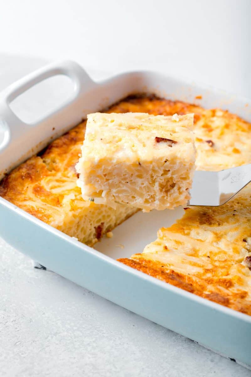 a slice of egg white breakfast casserole on a metal spatula being lifted up from the rest of the casserole