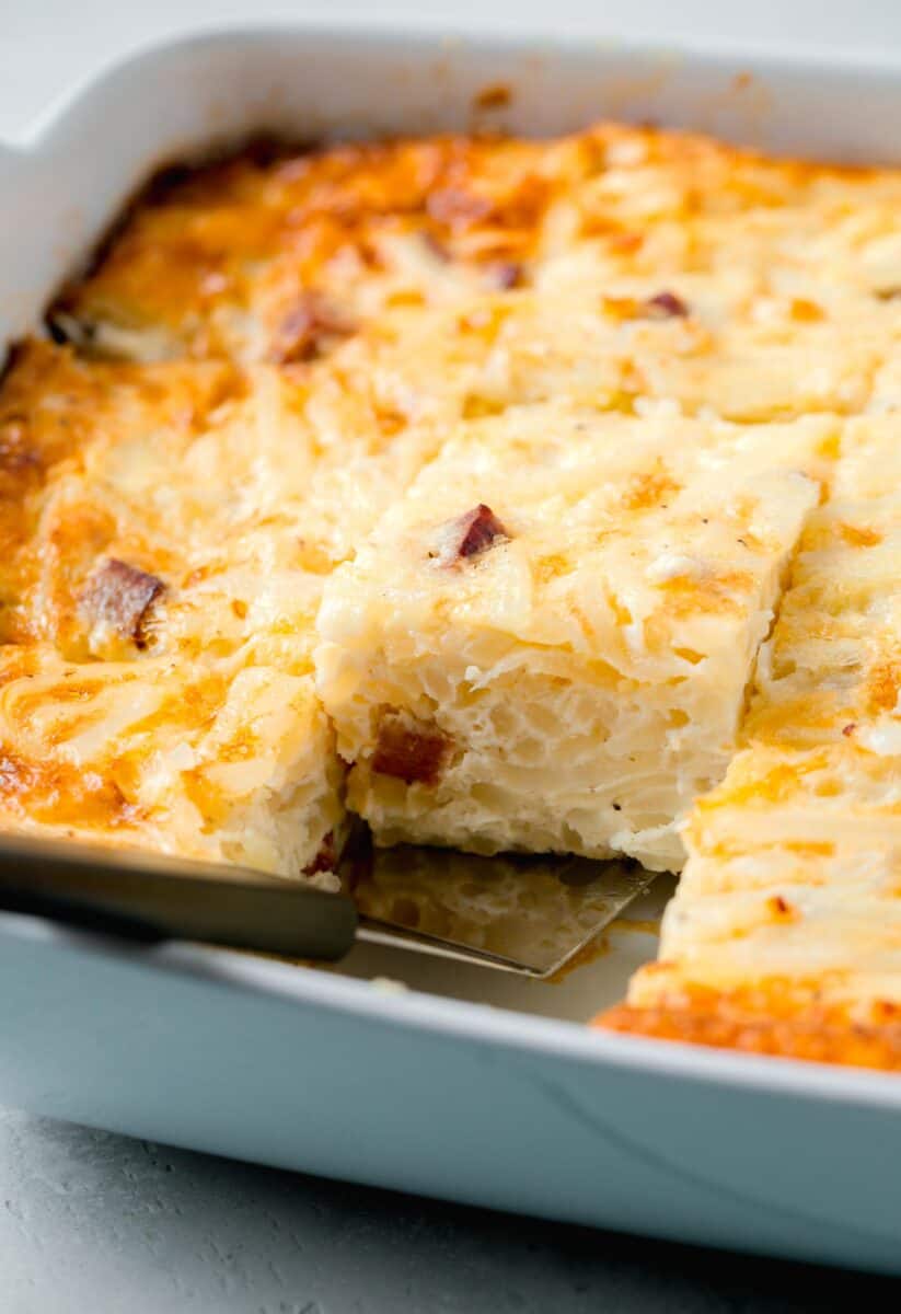 a piece of egg white breakfast casserole in a baking dish with a metal spatula underneath