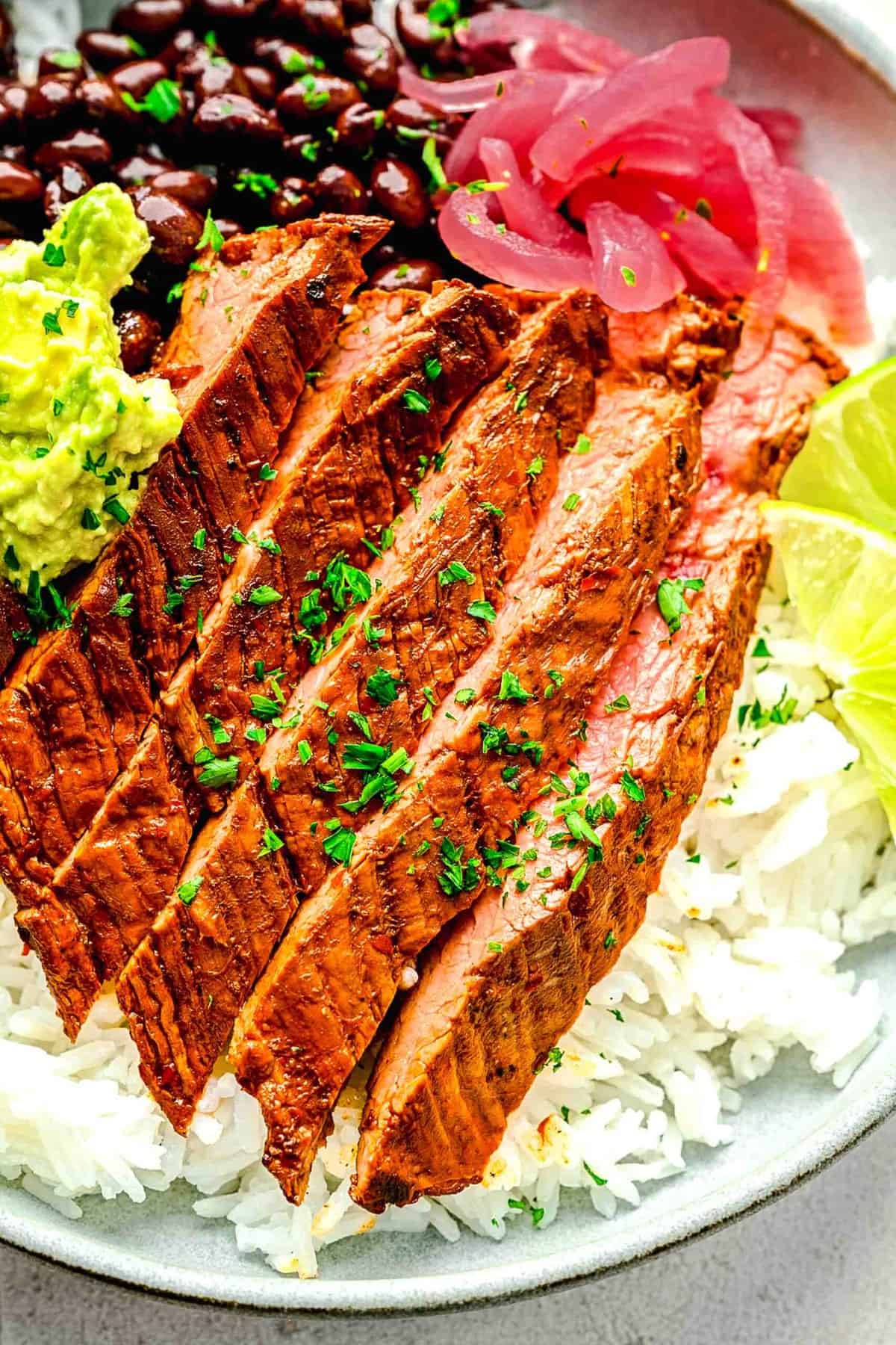 Closeup of garlic guajillo steak in a burrito bowl.