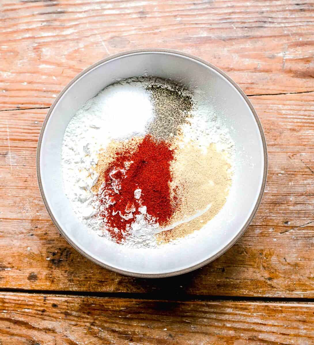 Ingredients for a flour coating for fried chicken in a bowl.