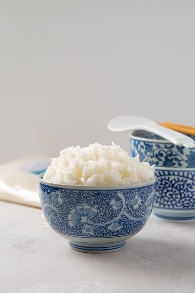 instant pot jasmine rice in a decorative blue bowl with other blue bowls in the background