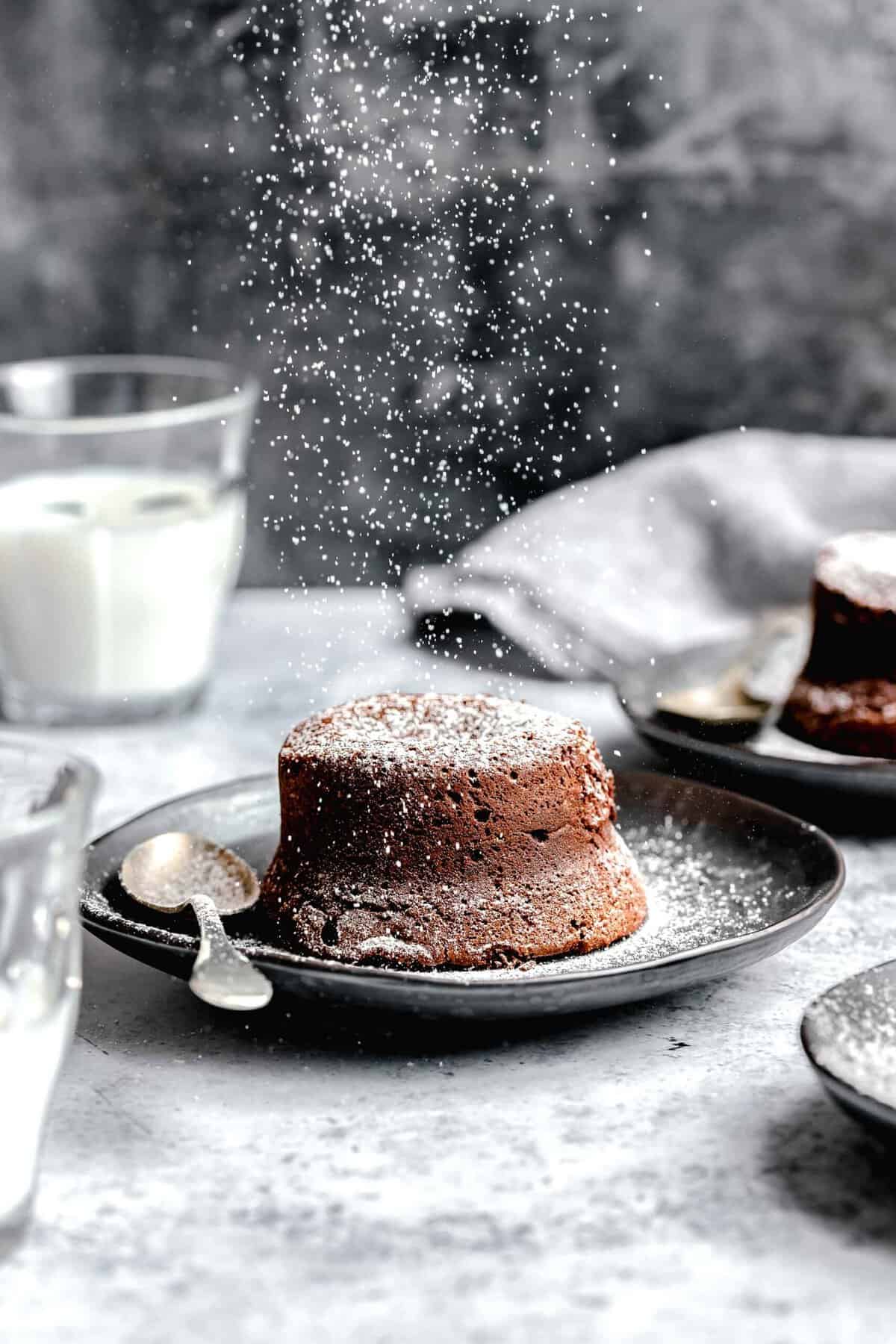 Dusting molten lava cake with powdered sugar.