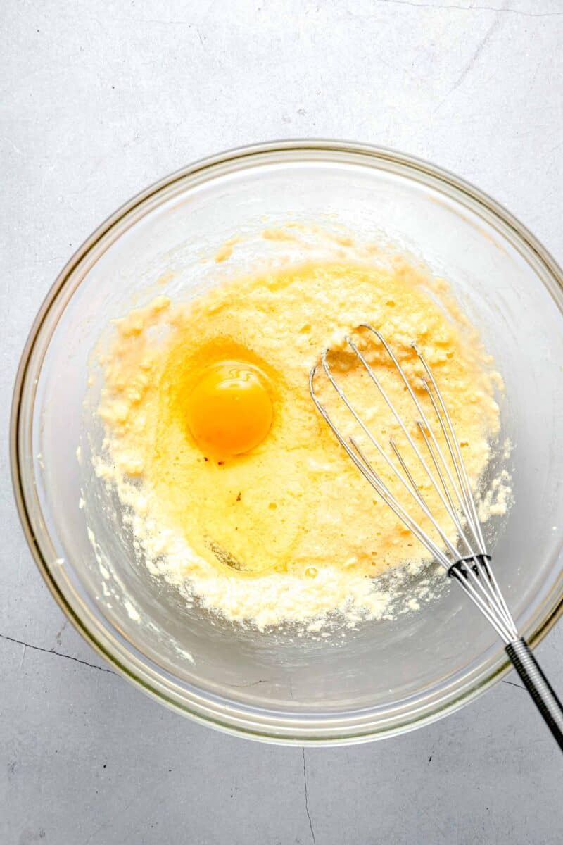 Adding an egg to cake batter.