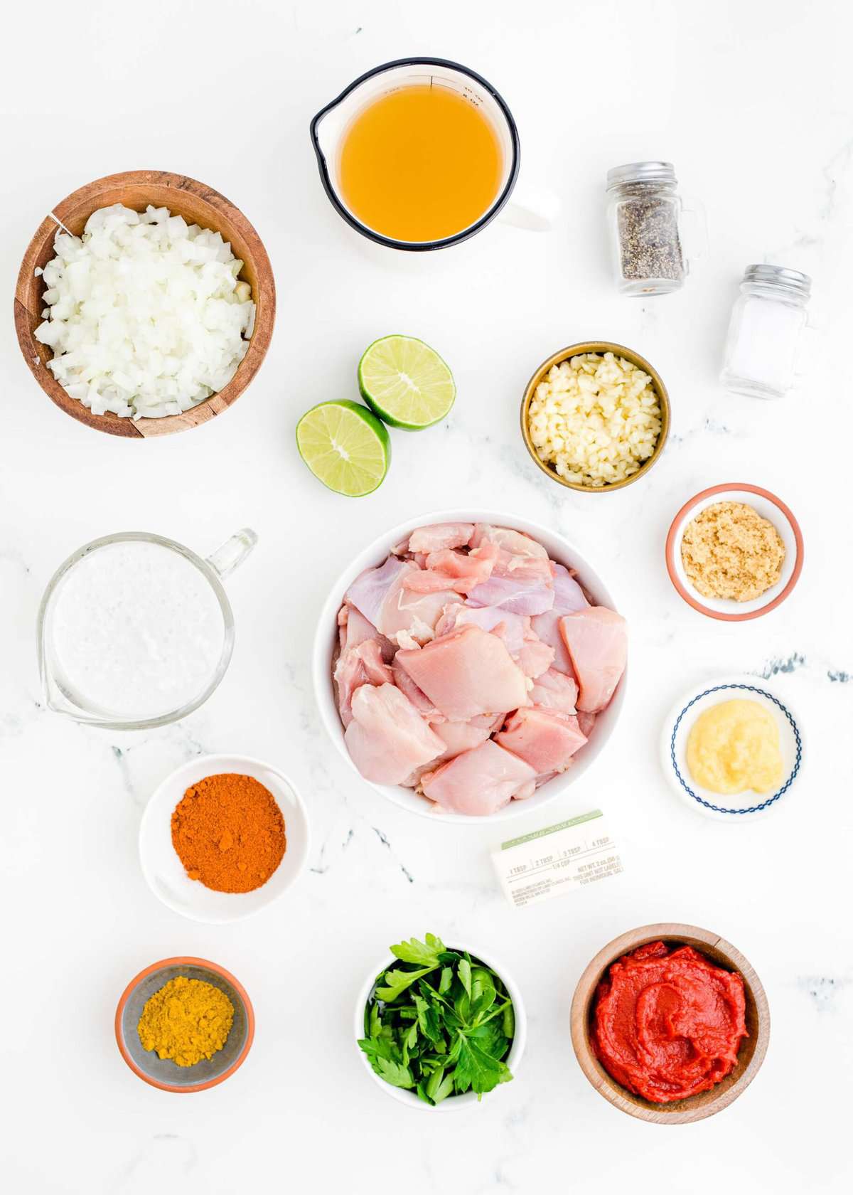 the ingredients for slow cooker butter chicken are placed on a white surface.