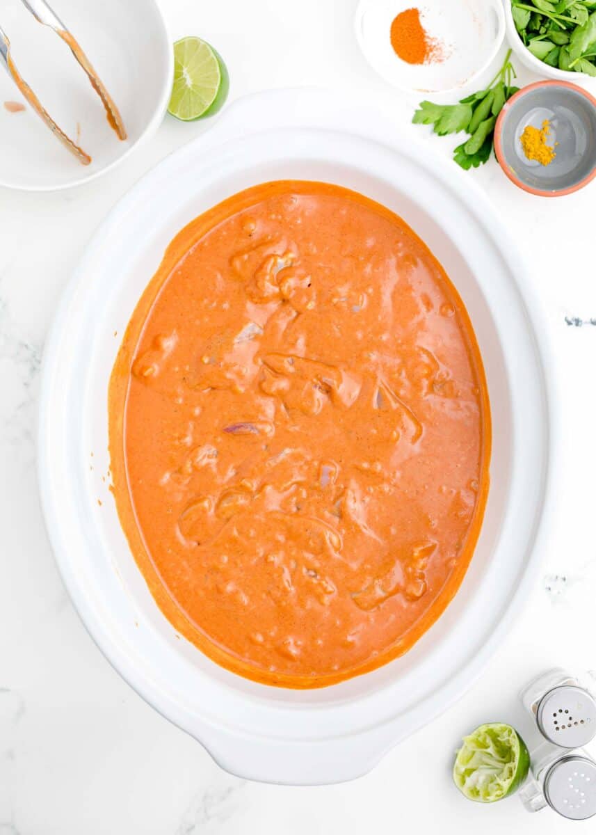 a slow cooker is filled with creamy butter chicken sauce.