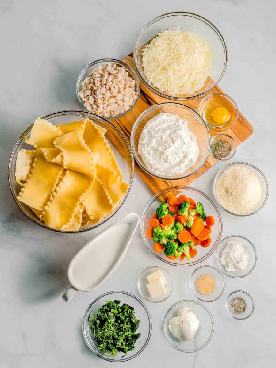 the ingredients for white sauce lasagna are placed on a countertop.