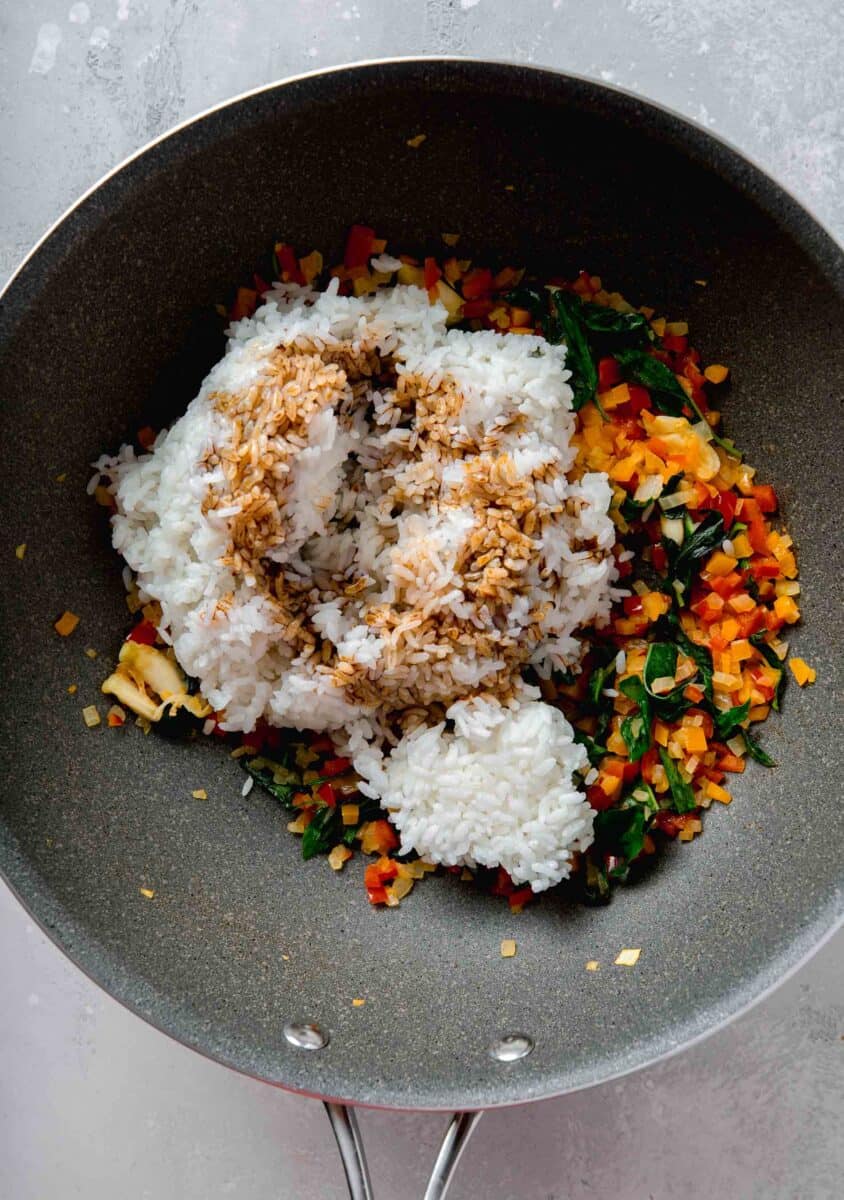 soy sauce mixture poured on top of white rice in the nonstick skillet