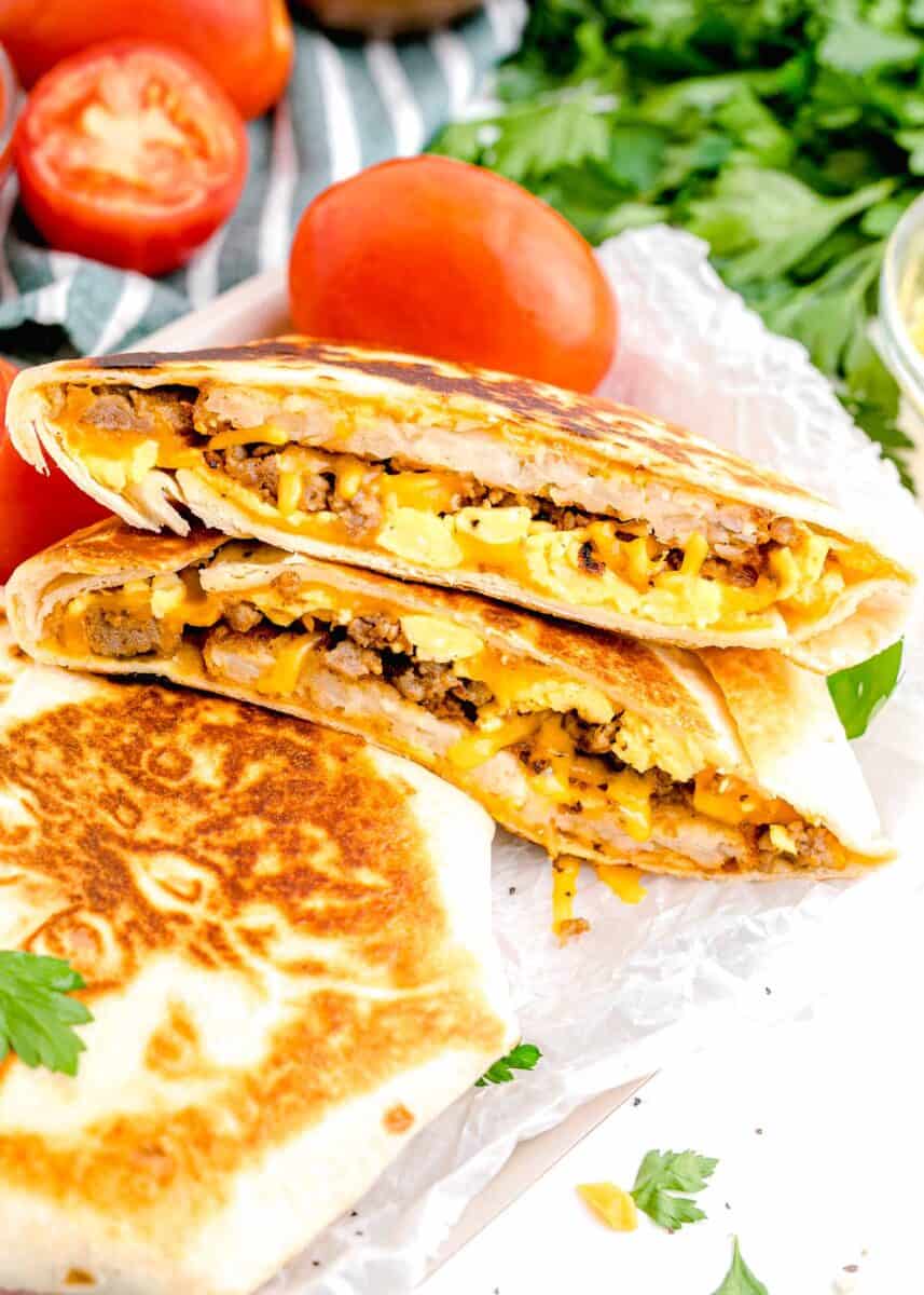 several crunchwraps are placed next to tomatoes.