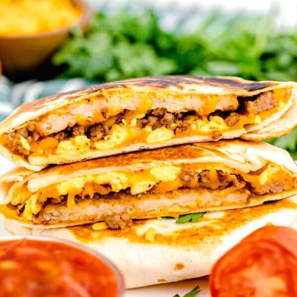 a stack of breakfast crunchwraps are placed next to some salsa.