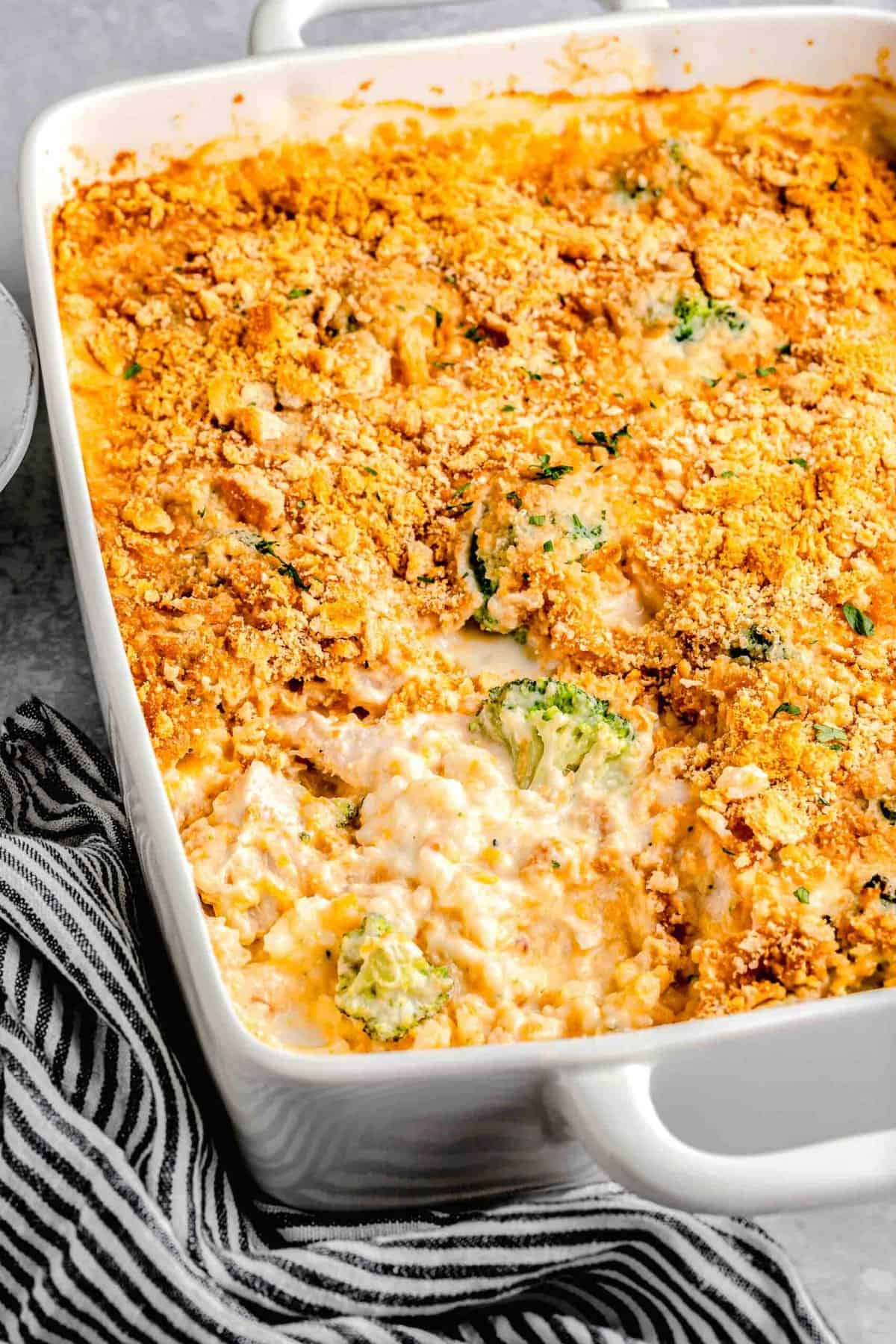 Chicken broccoli rice casserole in a casserole dish with a pice taken out of it.