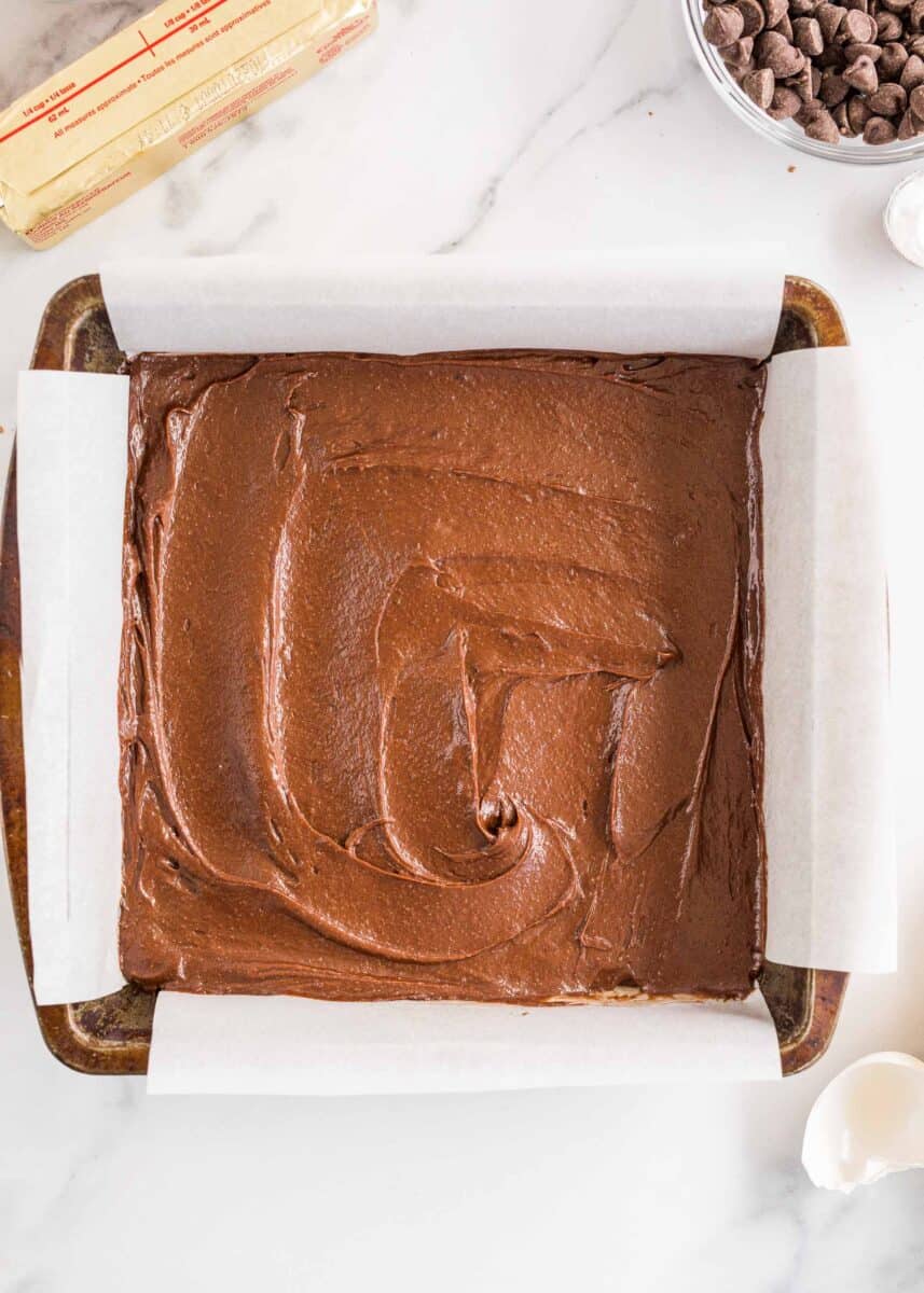 brownie batter is spread in an even layer in a baking dish.