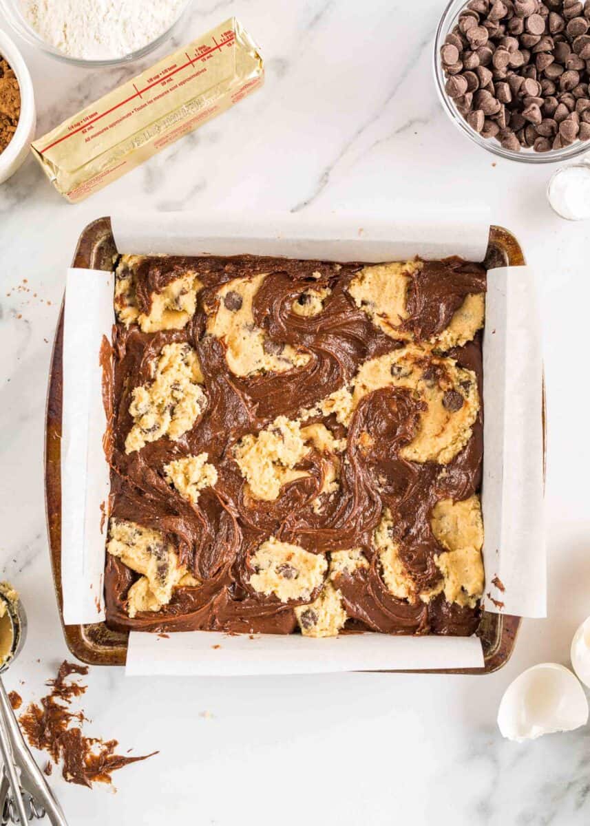 uncooked brookies are placed in a square dish.