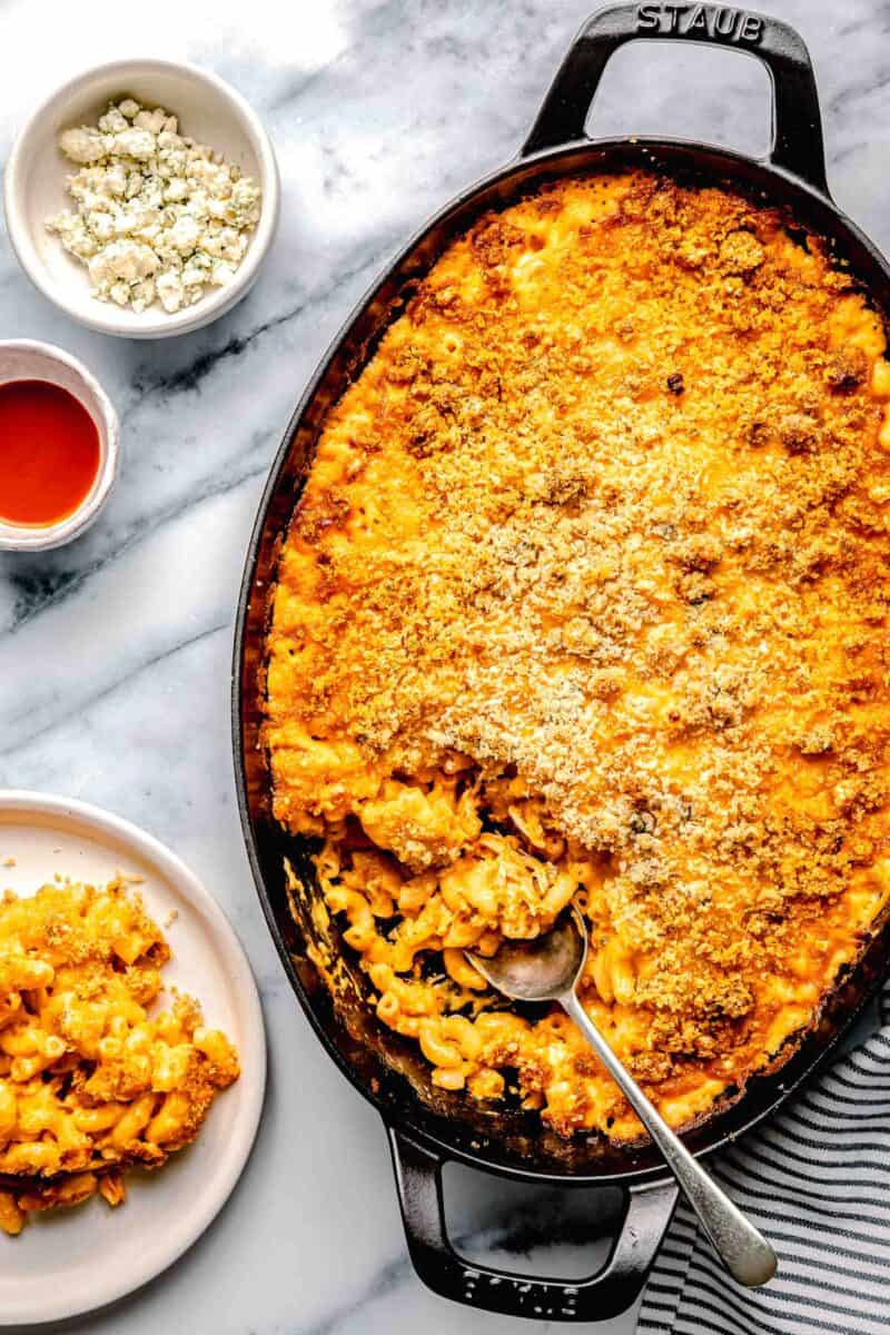 a spoon is placed inside of a dish filled with mac and cheese.