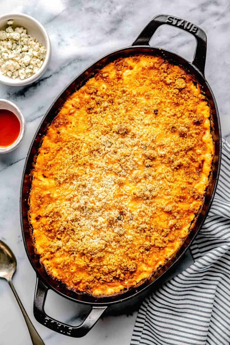 a large baking dish is filled with baked buffalo chicken mac and cheese.