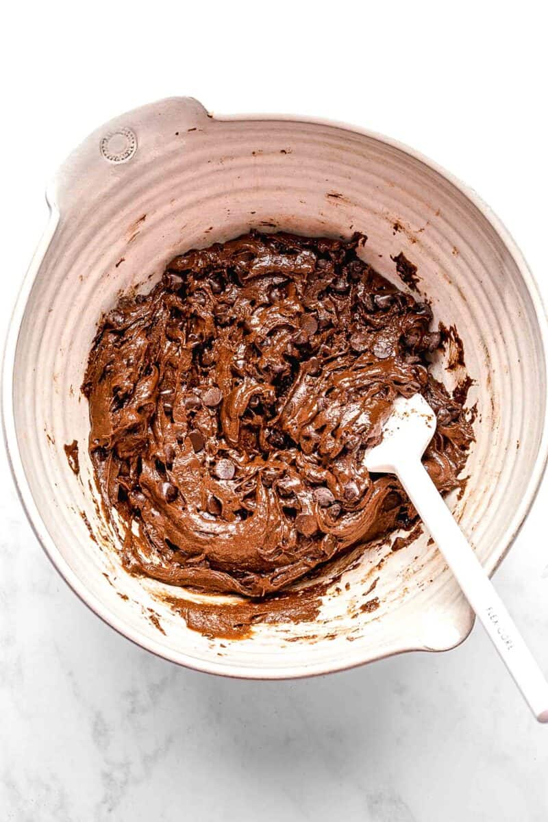 Mixing chocolate chips into brownie batter.