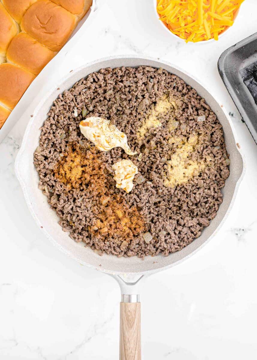 ground beef is in the process of being cooked in a skillet.