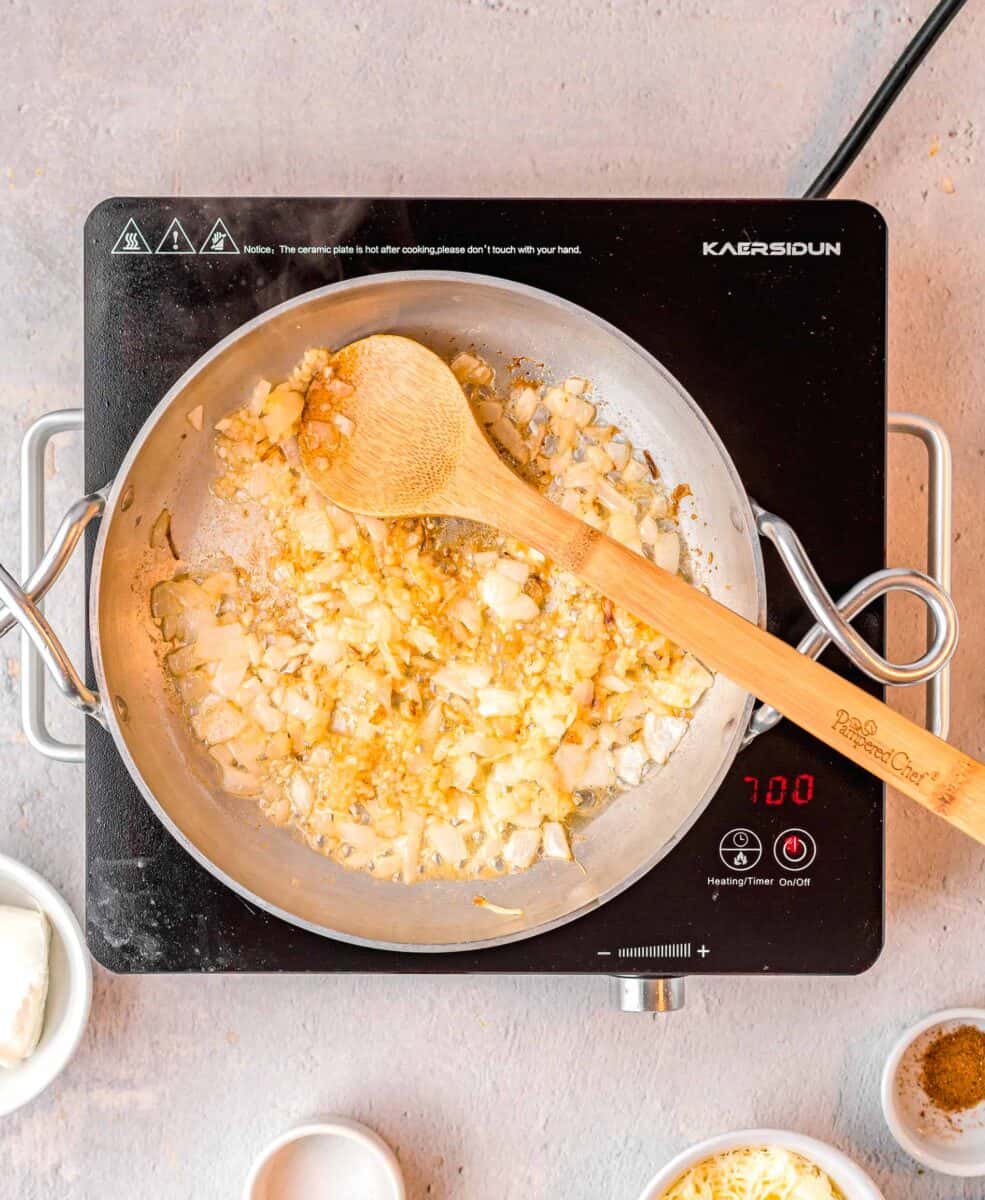 the first few ingredients for creamed spinach are being cooked in a skillet.