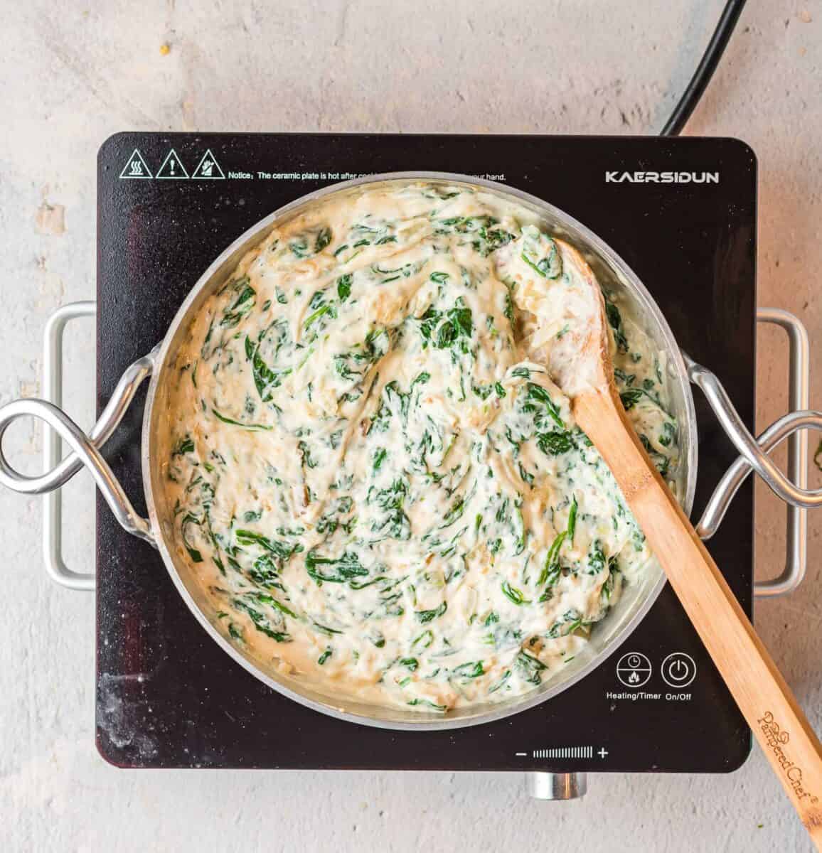 creamed spinach is being cooked in a skillet.