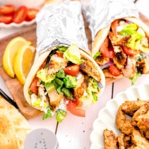 two gyros are placed next to a lemon slice.