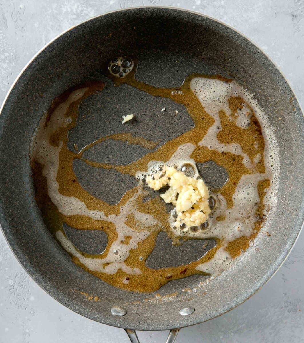 minced garlic added to melted butter in a nonstick skillet