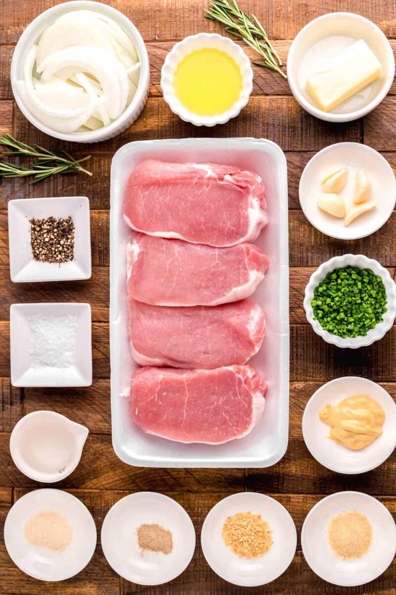 the ingredients for pork chops are placed on a wooden surface.