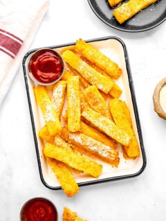 Polenta fries on a plate with ketchup.